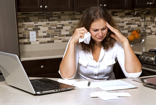 COST stressed woman looking on bills shutterstock 223473025 e1467309184292